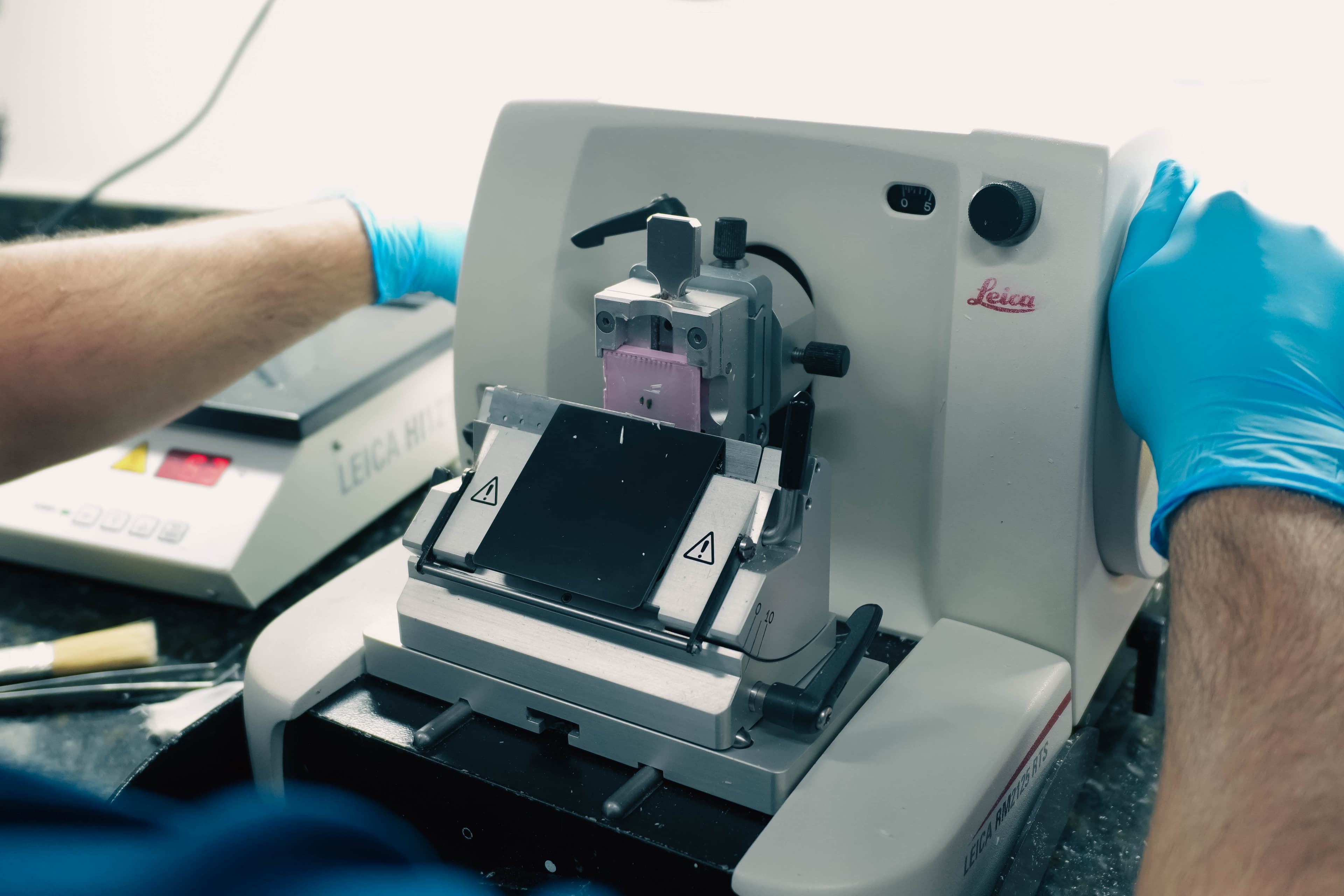 Técnico operando micrótomo Leica no Laboratório Citomed